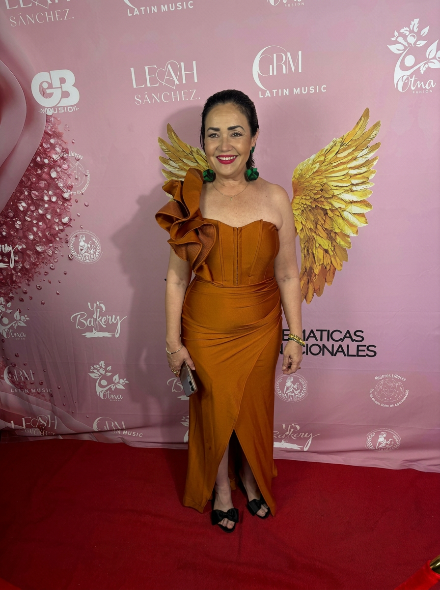 Xóchitl Lagunes en alfombra roja con vestido y alas doradas